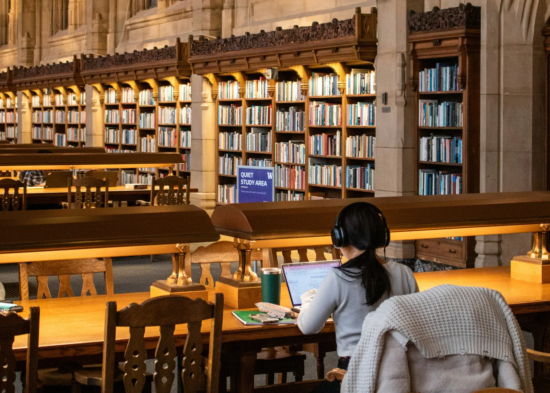 Studierender in einer großen Universitätsbibliothek