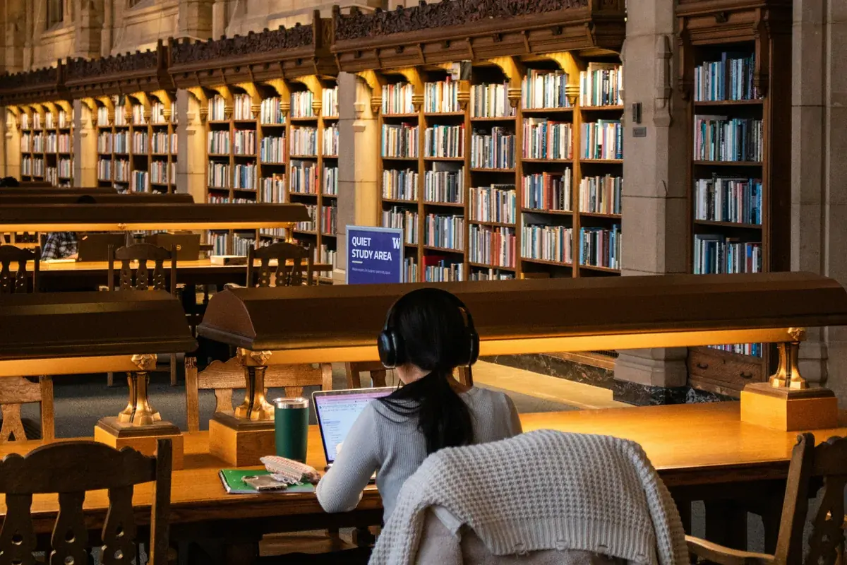 Studentin lernt mit Büchern in einer Bibliothek